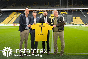 A lenda do Borussia Dortmund Wolfgang de Beer, Diretor de desenvolvimento de negócios da InstaForex Pavel Shkapenko, diretor de desenvolvimento de negócios da InstaForex da Ásia Roman Tcepelev e CEO da Borusssia Carsten Cramer segura a camisa simbólica da Borussia-Instaforex em frente ao campo do Singal Iduna Park Stadium